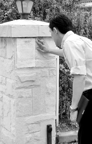 李天龙站在自家围栏前看城管的通知。李天龙供图